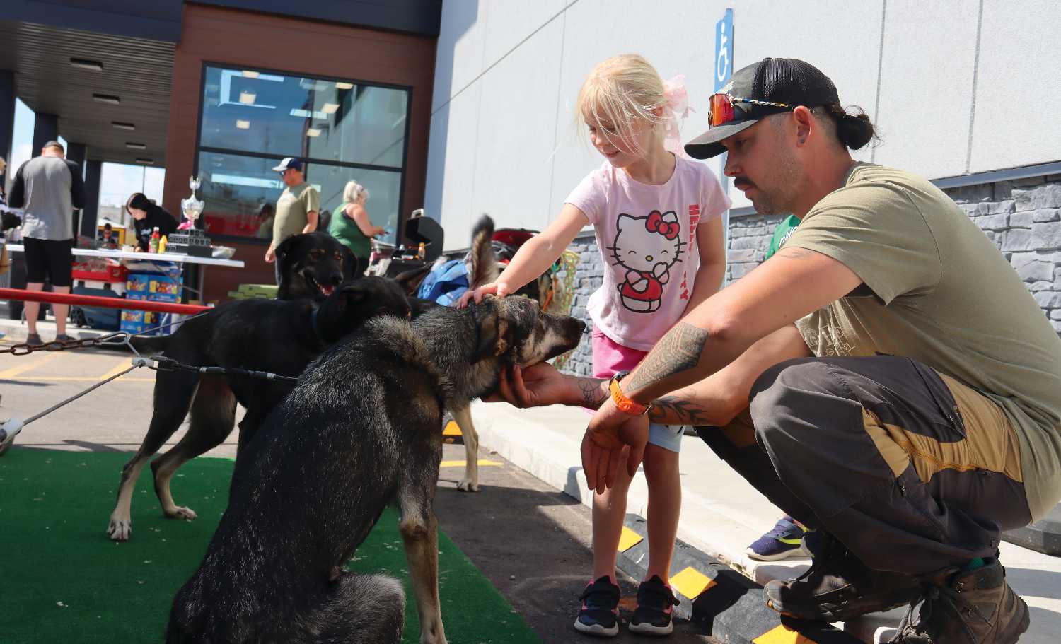 Garrick Schmidt with his dogs and one of the kids who came out to see them on August 23.